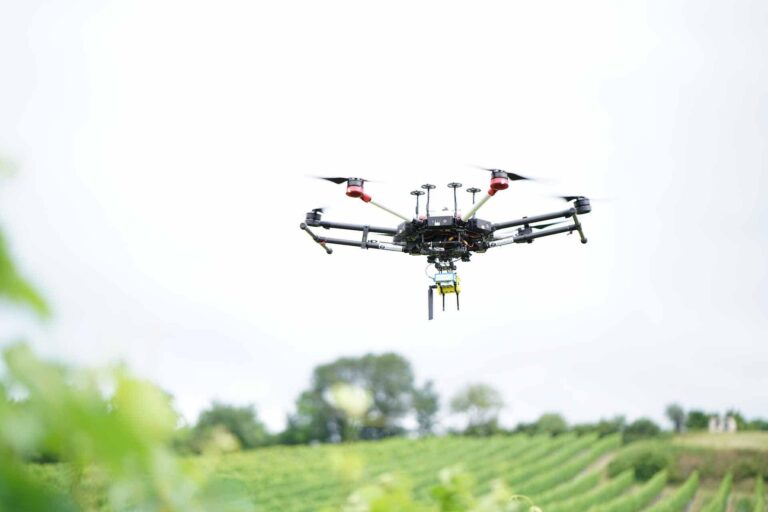 DJI M600 Drohne beim Flug über ein Feld mit Spezialsensoren