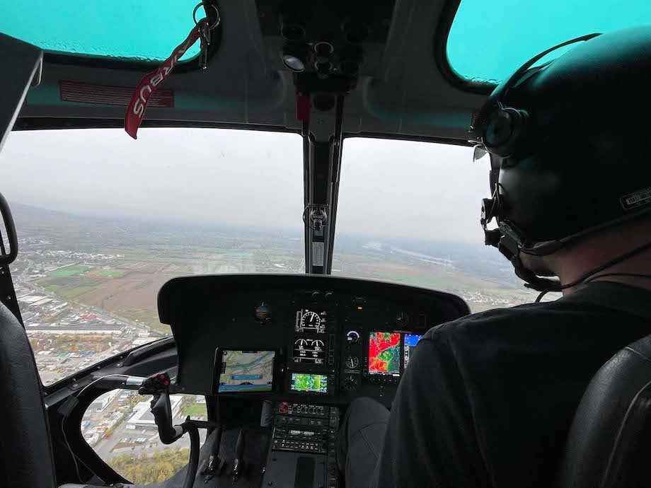 Hubschraubercockpit, AS355F, mit Pilot und Sicht auf Landschaft | Airborne Geodaten
