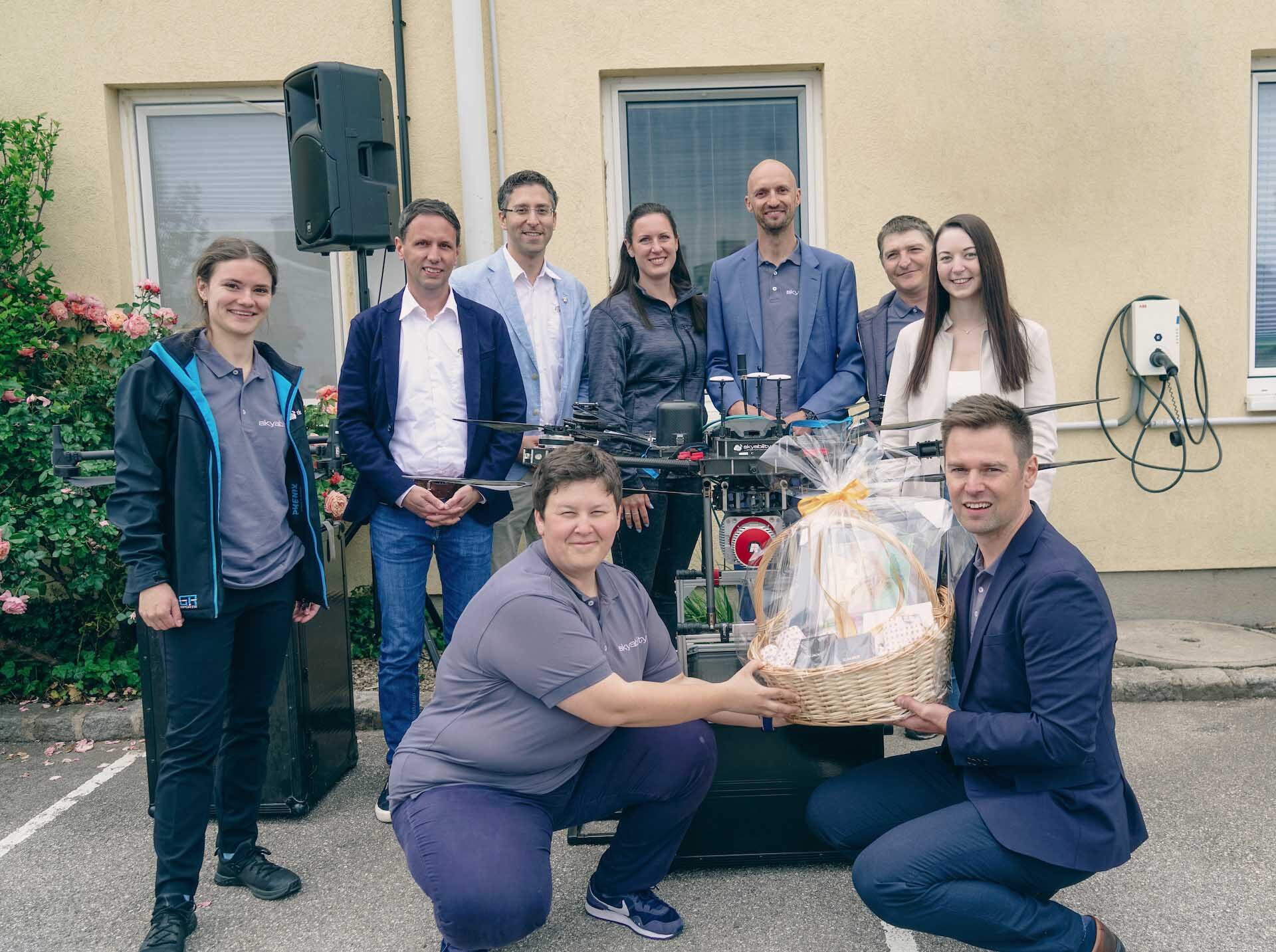 Gruppenfoto mit Team Skyability und Vertretern von RIEGL Measurment Systems hinter einer Drohne mit RIEGL VUX1SYS UAV Rotlichtscanner
