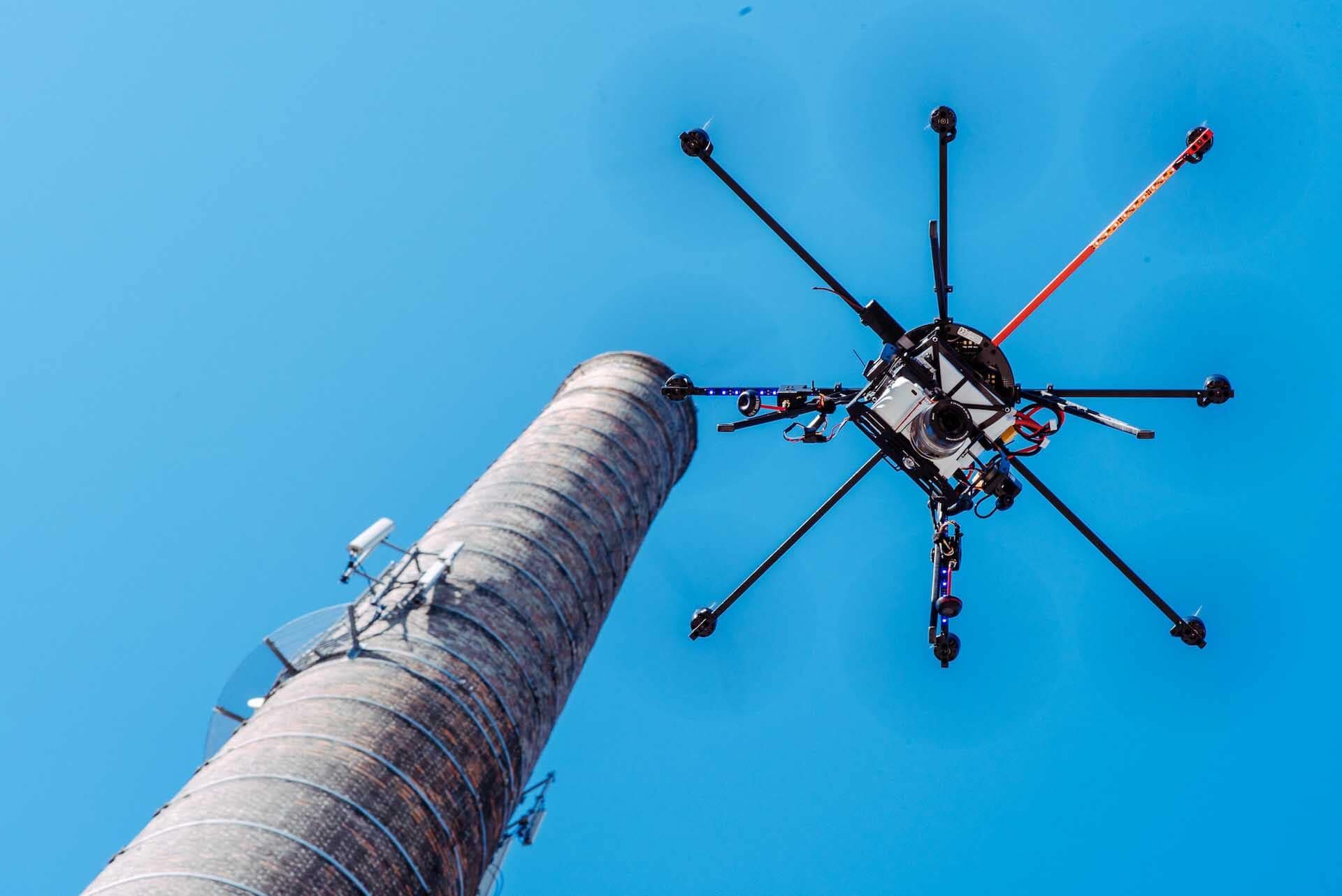 Froschperspektive MK-6s Kopter mit Digitalkamera vor Schornstein